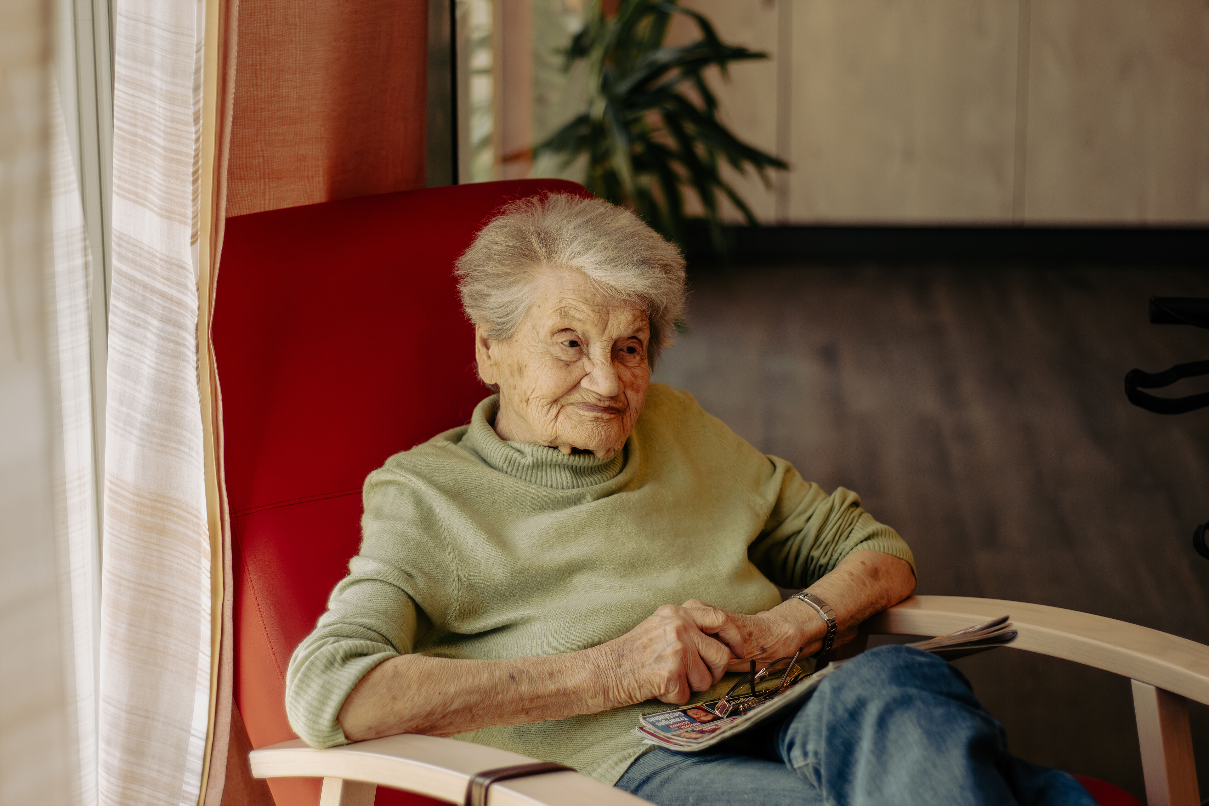 Ältere Dame sitzt im Sessel