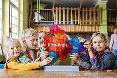 Kinder mit der Trophäe des deutschen KITA-Preises 2022