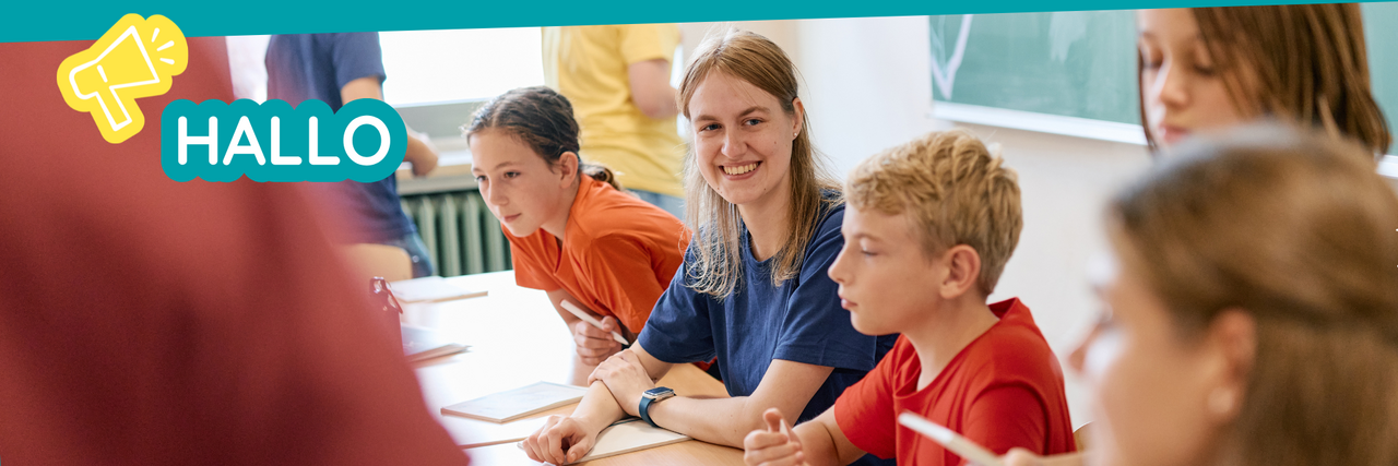 Kinder sitzen am Tisch in Klassenraum Kinder JRK