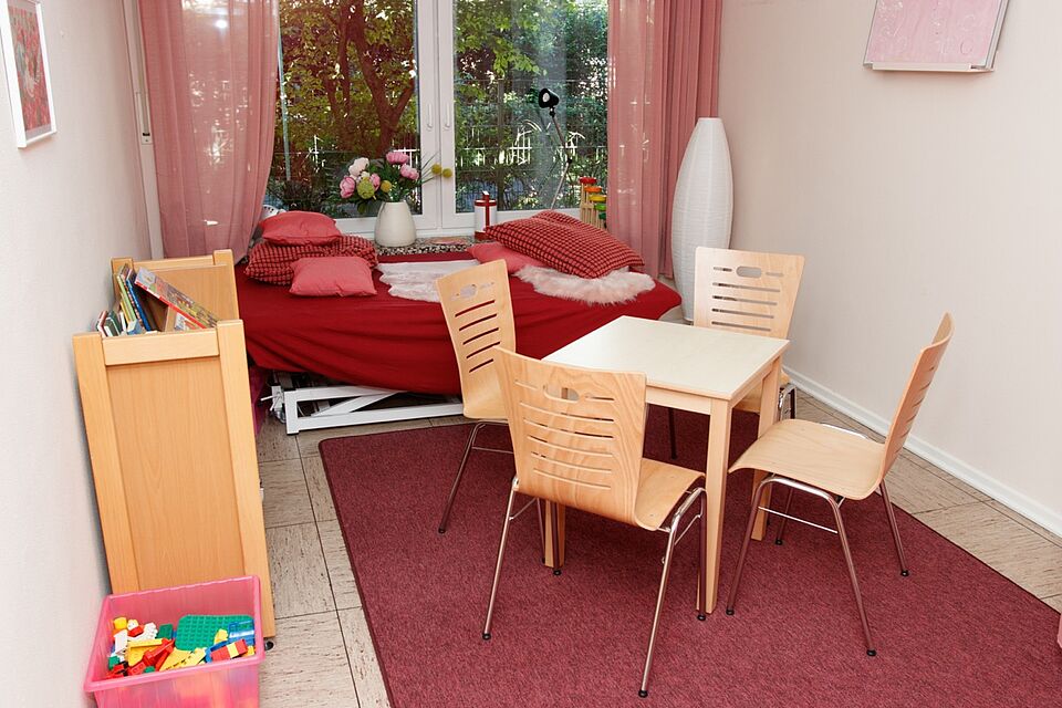 Raum mit Liege, Tischen und Stühlen