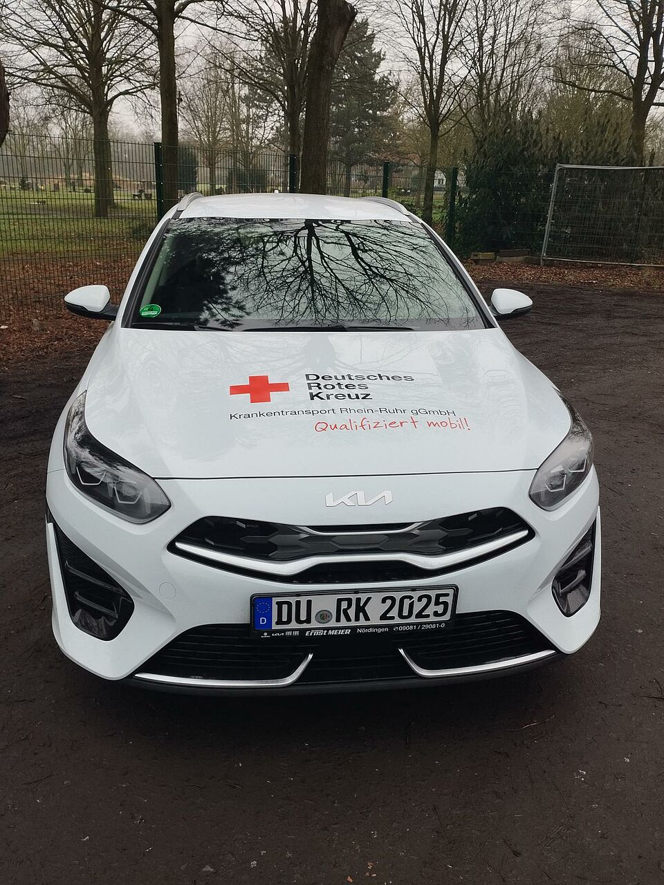 Zu sehen ist ein weißes Auto von vorne, mit dem Logo des DRK Duisburg. Es handelt sich hierbei um den neuen Kita Flitzer