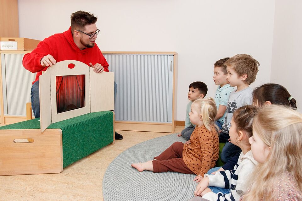 Kamishibai-Theater Erzieher präsentiert den Kita-Kindern ein Kamishibai Theater