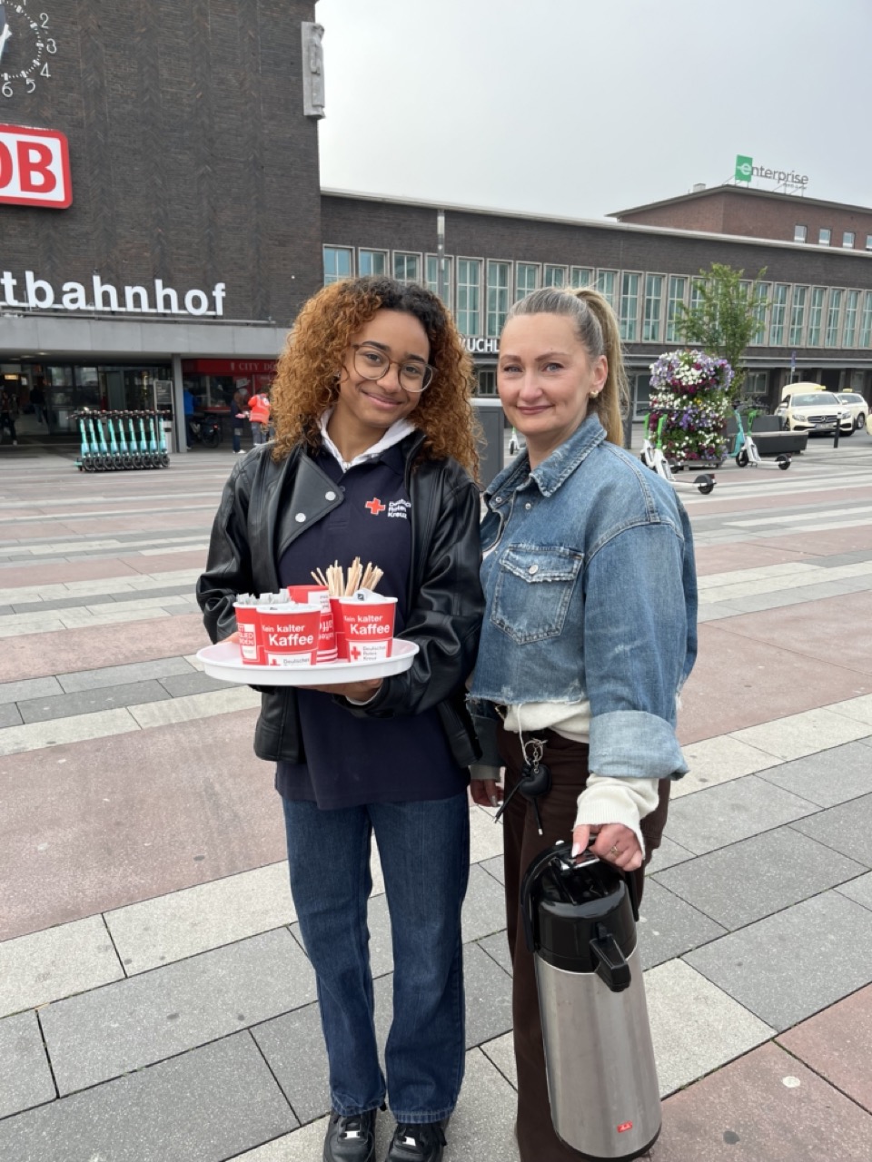 Rotkreuzmitarbeiterinnen verteilen Kaffee auf dem Bahnhofsvorplatz