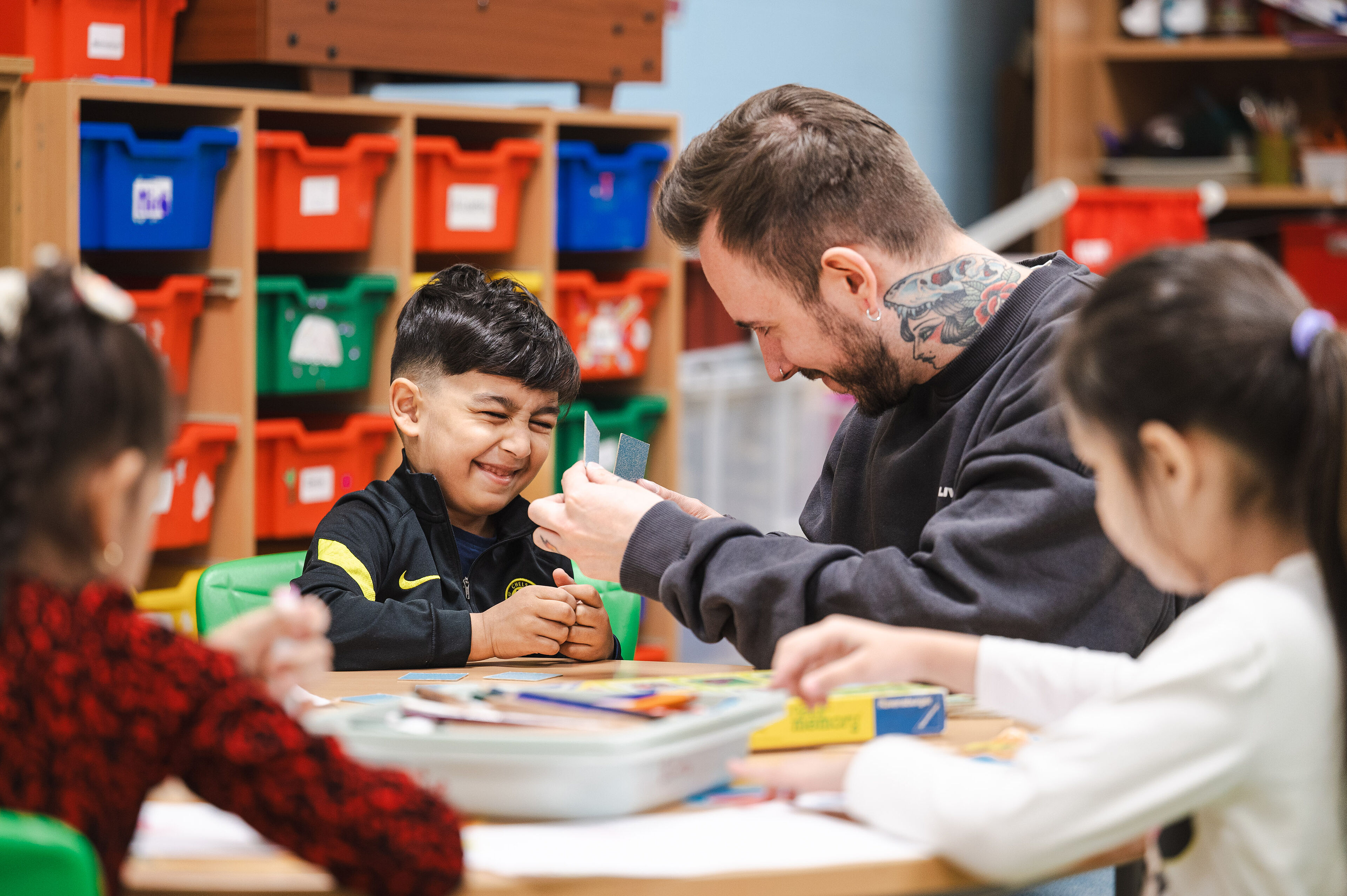 Betreuer und Kinder am Tisch basteln